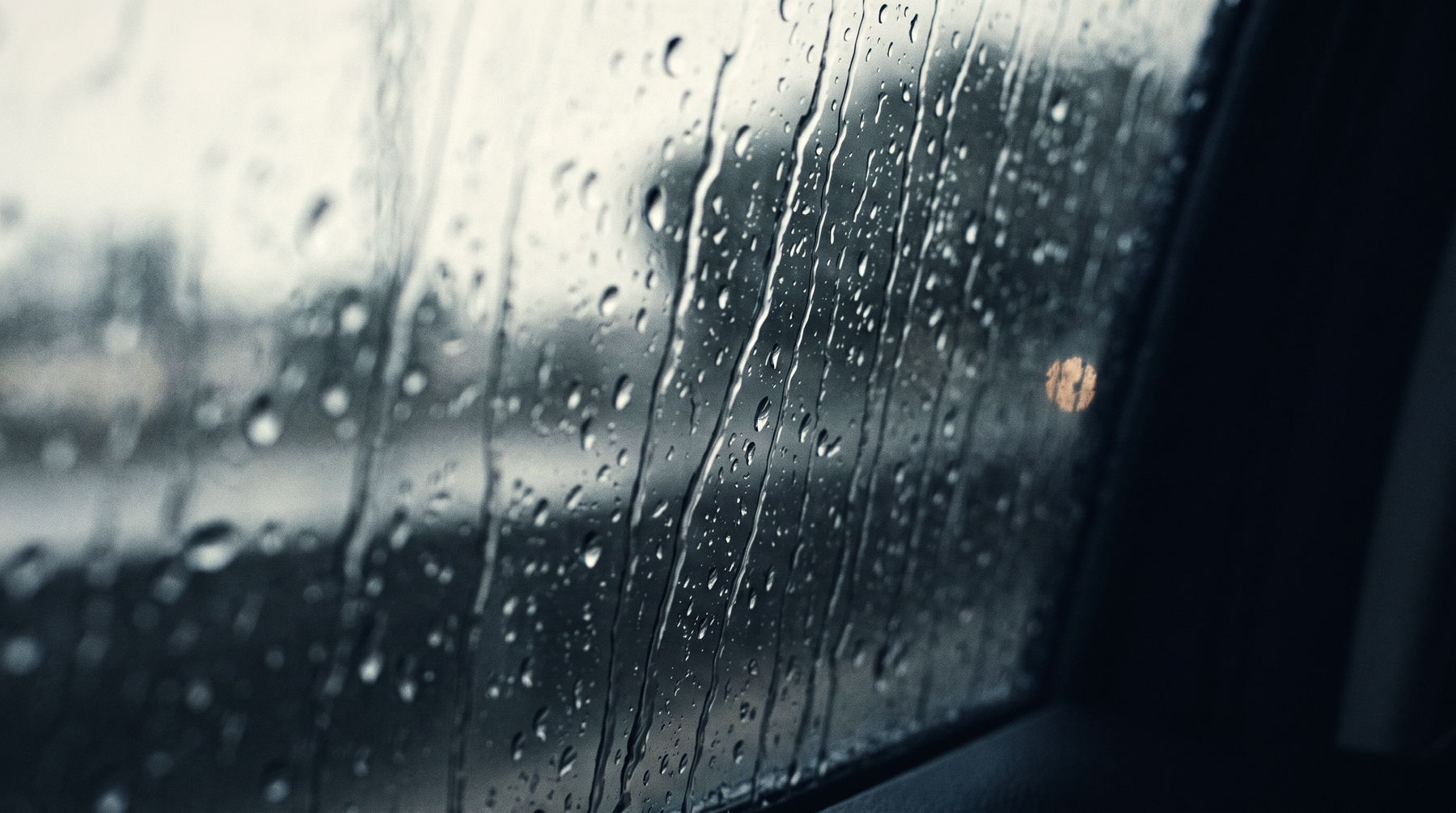 Rain running down dark glass